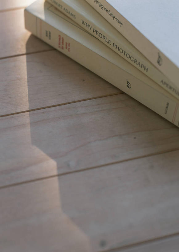 无人,竖图,俯视,室内,特写,白天,桌面,桌子,静物,书籍,一排,阴影,整齐,反射,木制,英文,标志,文字,影子,字符,字母,标识,排列,木制品,三本,堆,英文字母,队列,书,图书,彩图,高角度拍摄