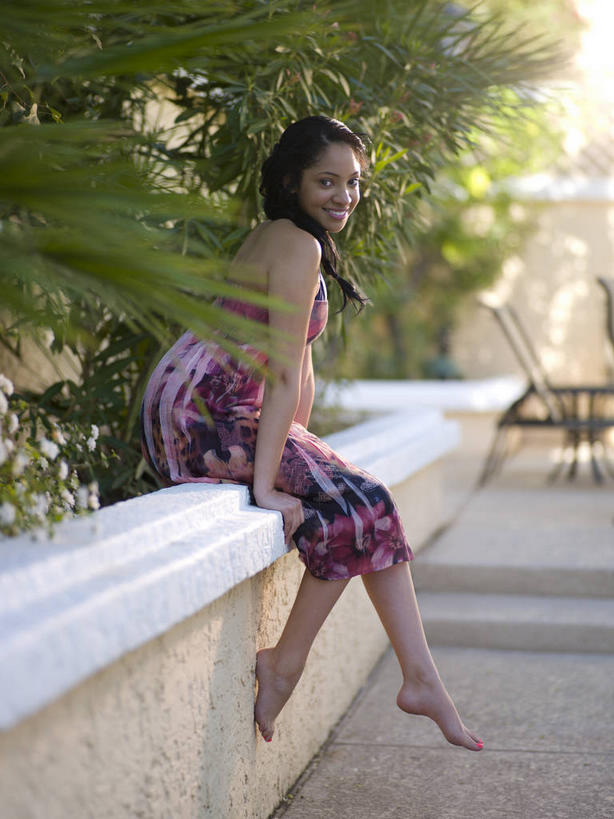 西方人,一个人,坐,笑,微笑,露齿笑,竖图,室外,白天,侧面,裙子,植物,欧洲,非洲,黑人,欧洲人,仅一个年轻女性,仅一个女性,仅一个人,撑,阴影,连衣裙,服装,光线,影子,扭头,注视,光脚,树,树木,衣服,绿色,阳光,自然,观察,看,转头,赤脚,服饰,生长,成长,观看,察看,撑着,衣着,穿着,关注,衣饰,年轻女性,女人,女性,非洲人,坐着,彩图,全身