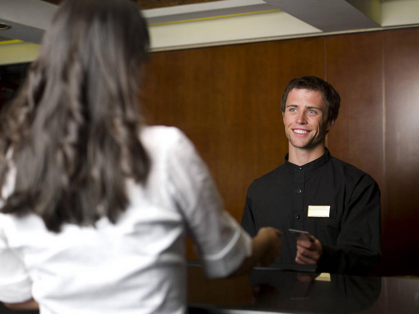 东方人,西方人,背部,两个人,前台,服务员,宾馆,站,笑,微笑,露齿笑,横图,室内,白天,正面,工作服,制服,桌子,欧洲,欧洲人,亚洲,握,服装,办公桌,拿,拿着,注视,休闲装,黄种人,标识,吊牌,相视,衣服,胸牌,观察,看,站着,休闲,面对面,休闲服,服务台,握着,服饰,观看,对视,察看,徽章,互视,关注,相对,身份,胸章,胸卡,相看,编号牌,雕刻牌,工号牌,胸号牌,胸徽,员工牌,工作制服,男人,男性,年轻男性,女人,女性,中年女性,白种人,亚洲人,服务生,侍者,站立,半身,彩图,工作套服,客店,客栈,旅店,旅馆,旅舍,汽车旅馆,帮助台,呼叫台