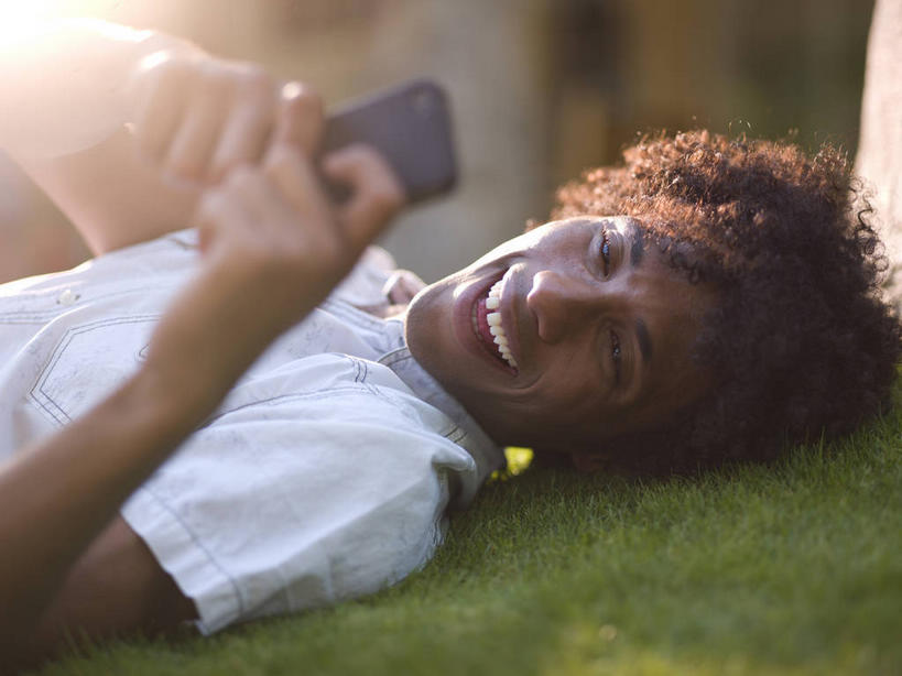 西方人,一个人,躺,笑,打电话,微笑,露齿笑,横图,俯视,室外,白天,草地,草坪,植物,电话,手机,欧洲,非洲,黑人,欧洲人,仅一个男性,仅一个人,握,阴影,服装,朦胧,模糊,光线,影子,拿,拿着,注视,休闲装,通讯设备,草,仅一个年轻男性,衣服,绿色,白色,阳光,观察,看,休闲,休闲服,握着,服饰,观看,察看,关注,一部,卧着,交流,男人,男性,年轻男性,非洲人,沟通,躺着,通话,卧,半身,彩图,高角度拍摄