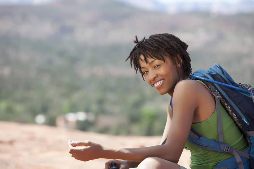 西方人,一个人,坐,笑,微笑,露齿笑,横图,室外,白天,侧面,旅游,度假,石头,美景,沙漠,山,山脉,植物,欧洲,非洲,黑人,欧洲人,仅一个年轻女性,仅一个女性,仅一个人,阴影,服装,朦胧,模糊,光线,包,石子,影子,景观,山峰,山峦,旅行包,扭头,注视,休闲装,娱乐,树,树木,衣服,绿色,阳光,自然,背包,群山,观察,看,转头,享受,休闲,休闲服,景色,放松,服饰,生长,成长,观看,察看,关注,自然风光,沉积岩,旅游包,水成岩,年轻女性,女人,女性,非洲人,大漠,砂漠,石块,岩石,坐着,半身,彩图,双肩包