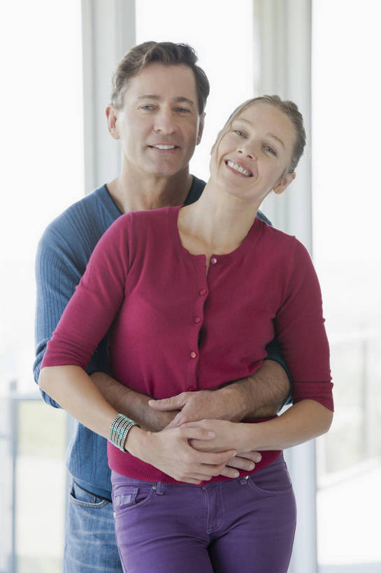 西方人,中年人,两个人,家庭,夫妻,站,抱,笑,微笑,露齿笑,竖图,室内,白天,正面,爱情,窗户,落地窗,欧洲,欧洲人,阴影,服装,反射,影子,浪漫,依偎,注视,休闲装,玻璃窗,衣服,观察,看,靠,靠着,倚靠,站着,休闲,温暖,温馨,一家人,休闲服,恩爱,恋人,服饰,抱着,观看,和睦,察看,搂着,倚着,关注,依附,依赖,投靠,男人,男性,女人,女性,中年男性,中年女性,白种人,夫妇,情侣,怀抱,搂,搂抱,相抱,拥抱,站立,半身,彩图,伴侣,融洽