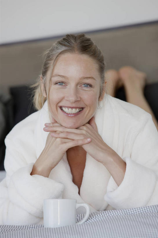 咖啡,西方人,一个人,举,笑,微笑,露齿笑,竖图,室内,白天,正面,浴袍,幸福,床,靠垫,卧室,杯子,欧洲,欧洲人,仅一个女性,仅一个人,服装,朦胧,模糊,瓷器,双人床,床单,咖啡杯,靠枕,陶瓷制品,一杯,注视,光脚,娱乐,被子,饮料,一个,衣服,白色,垫子,枕头,观察,看,趴着,托,仅一个中年女性,享受,休闲,温馨,赤脚,放松,乐趣,服饰,单个,观看,察看,提神,舒适,被单,衣着,穿着,关注,瓷杯,醒脑,软饮料,衣饰,女人,女性,中年女性,白种人,举起,举手,举着,趴,向上举,向上伸,向上托,彩图,全身,汤帷子,浴衣,睡房,卧房