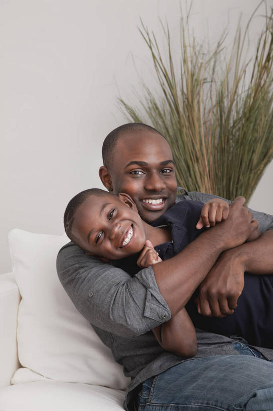 西方人,儿童,中年人,两个人,家庭,父亲,儿子,客厅,坐,抱,笑,微笑,露齿笑,竖图,室内,白天,正面,纯洁,植物,沙发,欧洲,非洲,黑人,欧洲人,阴影,服装,反射,盆栽,影子,墙,盆景,注视,休闲装,墙壁,墙面,小孩,衣服,绿色,白色,自然,观察,看,休闲,温暖,温馨,父子,一家人,休闲服,父爱,可爱,童年,童趣,服饰,生长,成长,抱着,观看,和睦,察看,起居室,搂着,关注,布艺沙发,童真,烂漫,无邪,客堂,天真,男孩,男人,男性,中年男性,非洲人,孩子,怀抱,搂,搂抱,相抱,拥抱,坐着,半身,彩图,融洽,男生