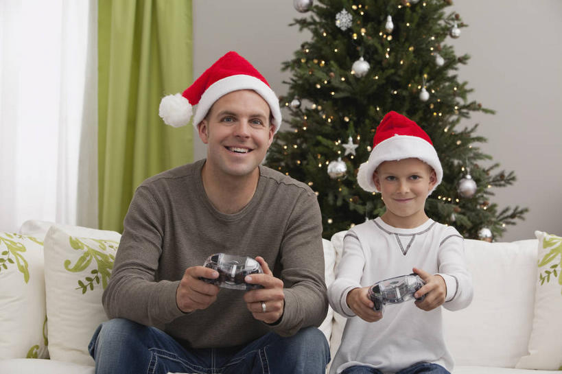 西方人,儿童,中年人,两个人,家庭,父亲,儿子,客厅,坐,笑,微笑,露齿笑,横图,室内,白天,正面,游戏,纯洁,植物,窗帘,靠垫,沙发,帽子,欧洲,圣诞节,欧洲人,握,服装,裤子,节日,庆祝,装饰,挂饰,墙,圣诞树,靠枕,圣诞球,拿,玩,拿着,注视,牛仔裤,休闲装,文化,娱乐,墙壁,墙面,球,树,树木,小孩,衣服,红色,绿色,自然,帘子,垫子,枕头,观察,看,庆典,休闲,球体,温暖,温馨,父子,一家人,休闲服,圣诞帽,遮阳,父爱,可爱,童年,童趣,握着,服饰,游戏机,生长,成长,观看,活动,纪念,手柄,华丽,修饰,点缀,和睦,控制,察看,起居室,游戏手柄,发泄,关注,消遣,智力,布艺沙发,童真,烂漫,无邪,宣泄,衬托,美观,雅致,雅观,棉帽,客堂,天真,男孩,男人,男性,中年男性,白种人,孩子,玩耍,嬉戏,坐着,半身,彩图,融洽,男生