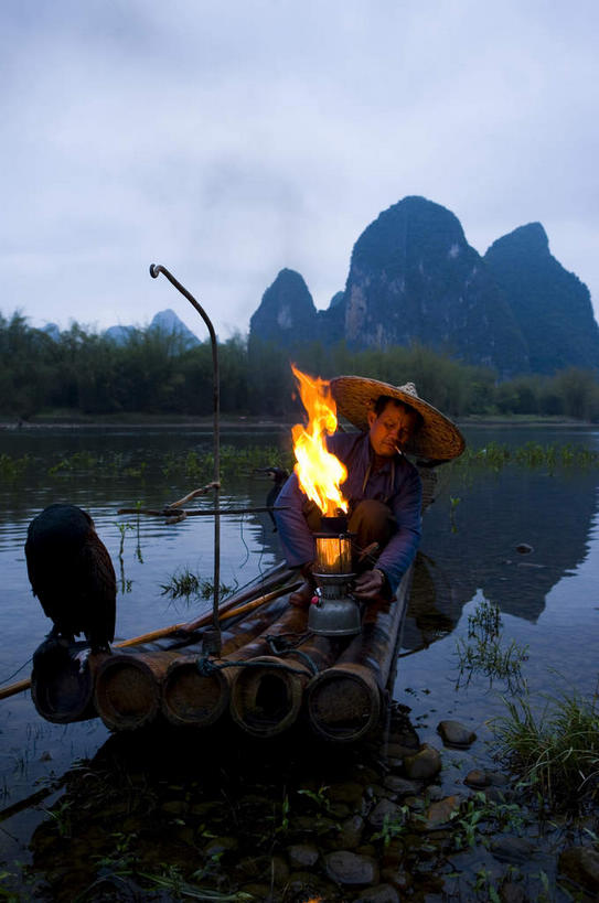东方人,一个人,渔夫,蹲,竖图,室外,白天,正面,旅游,度假,热情,河流,美景,日落,山,山脉,水,植物,鸟,火,帽子,照明,桂林,中国,亚洲,仅一个男性,仅一个人,一排,一艘,握,波纹,竹制,服装,整齐,编织,鸬鹚,鸟类,船桨,火焰,竹排,河水,景观,山峰,水流,晚霞,霞光,落日,灯光,运输工具,涟漪,山峦,背光,燃烧,拿,拿着,注视,休闲装,黄种人,娱乐,捕鱼,煤油灯,竹筏,灯,斗笠,树,树木,排列,仅一个年轻男性,一个,一只,衣服,黄色,绿色,倒影,水纹,自然,黄昏,灯具,交通工具,波浪,群山,观察,看,享受,休闲,休闲服,遮阳,景色,彩霞,放松,握着,服饰,生长,单个,成长,观看,广西,竹条,照亮,察看,倒映,竹制品,照明设备,队列,关注,自然风光,载具,逆光,鱼鹰,水老鸦,东亚,漓江,阳朔,广西壮族自治区,中华人民共和国,桂林市,桂,华南地区,水晕,夕照,反照,薄暮,水上交通工具,笠帽,阳朔县,兴坪,兴坪镇,男人,男性,年轻男性,亚洲人,捕鱼人,打鱼人,夕阳,蹲着,彩图,全身,傍晚,编结帽,箬笠,蔽雨,马灯,斜阳