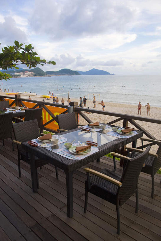 东方人,栏杆,露台,站,竖图,室外,白天,正面,旅游,度假,烹饪,西餐,海浪,海洋,美景,沙滩,山,山脉,植物,餐桌,桌子,指示牌,餐具,椅子,三亚,中国,亚洲,行人,游客,游人,吊挂,悬挂,阴影,服装,光线,标志,碟子,盘,沙子,影子,陶瓷,木椅,海岸,景观,浪花,山峰,云,云朵,围栏,横幅,三明治,料理,食品,枝条,陶瓷制品,沙地,山峦,许多人,挂,云彩,注视,休闲装,黄种人,娱乐,标识,菜肴,美食,护栏,路人,旅客,树,树木,树枝,海南,食物,衣服,红色,蓝色,绿色,白云,蓝天,天空,阳光,自然,海水,盘子,餐巾,容器,碟,碗,快餐,群山,天,观察,看,站着,一群人,享受,休闲,休闲服,景色,放松,西式,服饰,海南省,佳肴,生长,晴朗,成长,餐台,观看,储藏,察看,储存,关注,自然风光,海景,西式快餐,东亚,三文治,三亚市,中华人民共和国,华南地区,琼,虬枝,枝杈,过客,保洁方巾,口布,男人,男性,年轻男性,年轻女性,女人,女性,亚洲人,大海,风浪,海,海水的波动,海滩,近岸浪,涌浪,晴空,站立,半身,彩图,晒台,天台,眺望台,贮存