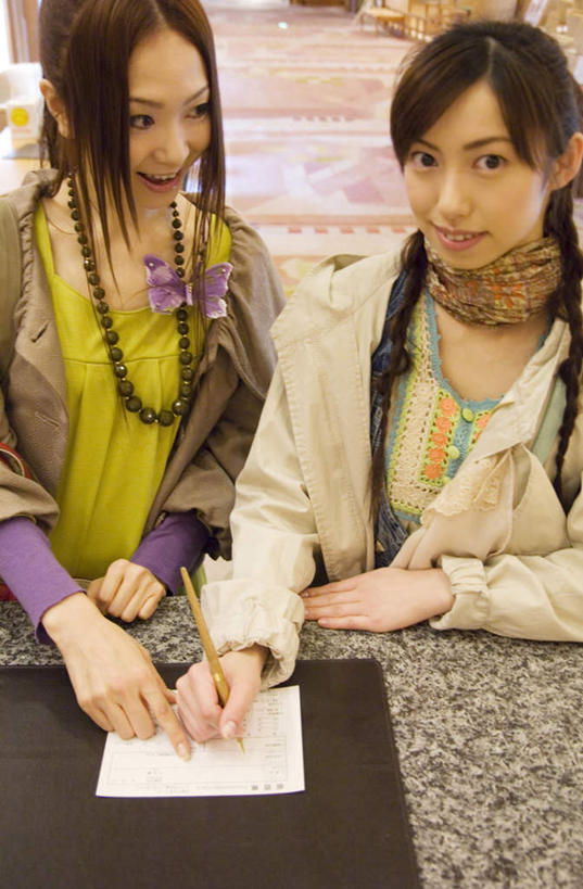 东方人,两个人,伙伴,朋友,前台,宾馆,笑,微笑,露齿笑,竖图,俯视,室内,白天,旅游,度假,友谊,亚洲,一张,握,指,服装,笔,纸,办公用品,拿,拿着,注视,休闲装,黄种人,娱乐,文具,衣服,学习用品,观察,看,享受,休闲,休闲服,放松,握着,服饰,观看,文具用品,察看,关注,友情,年轻女性,女人,女性,亚洲人,半身,彩图,高角度拍摄,客店,客栈,旅店,旅馆,旅舍,汽车旅馆