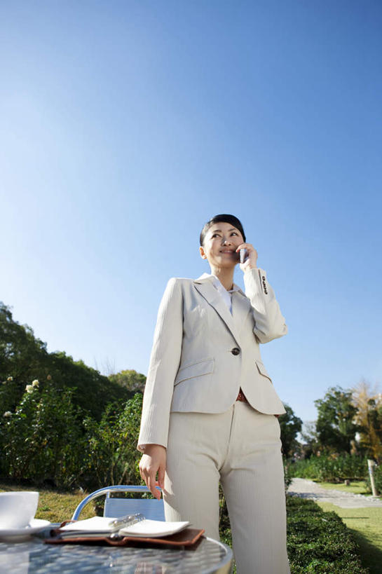 东方人,一个人,商务人士,商务女性,站,打电话,竖图,室外,白天,仰视,树林,植物,餐桌,桌面,桌子,杯子,餐具,电话,手机,椅子,金属制品,亚洲,仅一个女性,仅一个人,一本,握,阴影,套装,朦胧,模糊,光线,金属,瓷器,碟子,盘,影子,记事本,咖啡杯,陶瓷制品,拿,拿着,注视,黄种人,通讯设备,树,树木,一只,蓝色,绿色,白色,蓝天,天空,阳光,自然,本子,笔记本,盘子,碟,天,观察,看,站着,仅一个中年女性,握着,生长,晴朗,成长,餐台,观看,察看,关注,瓷杯,商务装,工薪阶层,万里无云,一部,交流,女人,女性,中年女性,亚洲人,白领,上班族,晴空,晴空万里,沟通,通话,站立,半身,彩图,低角度拍摄