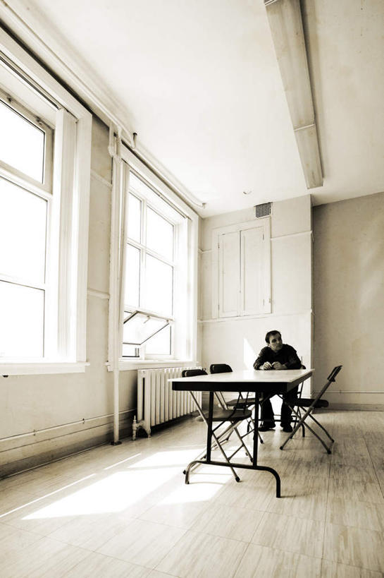 西方人,一个人,坐,竖图,室内,白天,正面,窗户,地板,桌面,桌子,椅子,欧洲,欧洲人,仅一个男性,仅一个人,一排,阴影,整齐,光线,木制,影子,木椅,墙,地面,木地板,玻璃窗,墙壁,墙面,排列,仅一个年轻男性,阳光,木制品,队列,男人,男性,年轻男性,白种人,坐着,彩图,全身