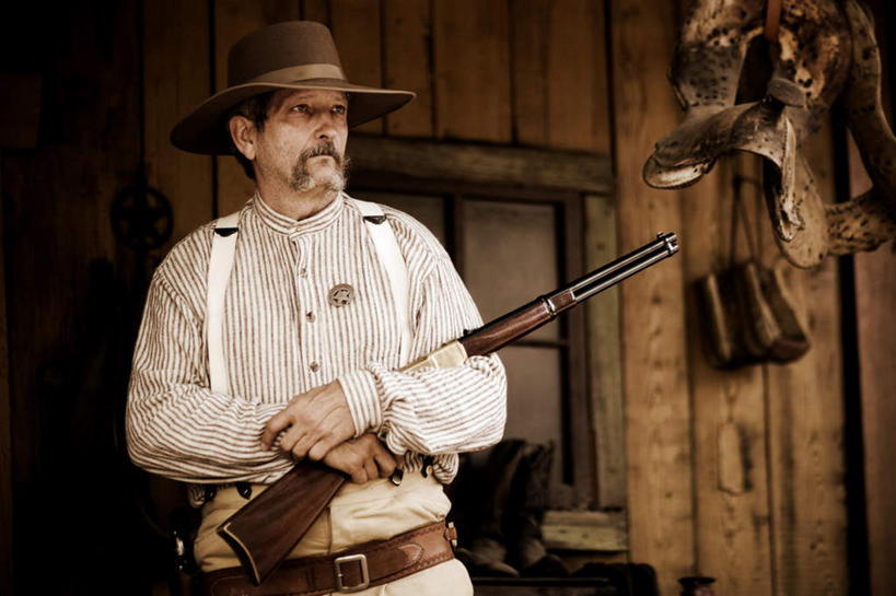 西方人,一个人,站,横图,室外,白天,正面,竞争,帽子,欧洲,欧洲人,仅一个男性,仅一个人,仅一个中年男性,对抗,阴影,冲突,光线,枪支,影子,墙,注视,破坏,墙壁,墙面,阳光,观察,看,站着,牛仔帽,武器,战争,观看,损坏,察看,攻击,威胁,对立,关注,矛盾,兵器,防御,来复枪,敌对,挫败,斗争,抗拒,抗衡,杀伤,威慑,危险,男人,男性,中年男性,白种人,站立,半身,彩图