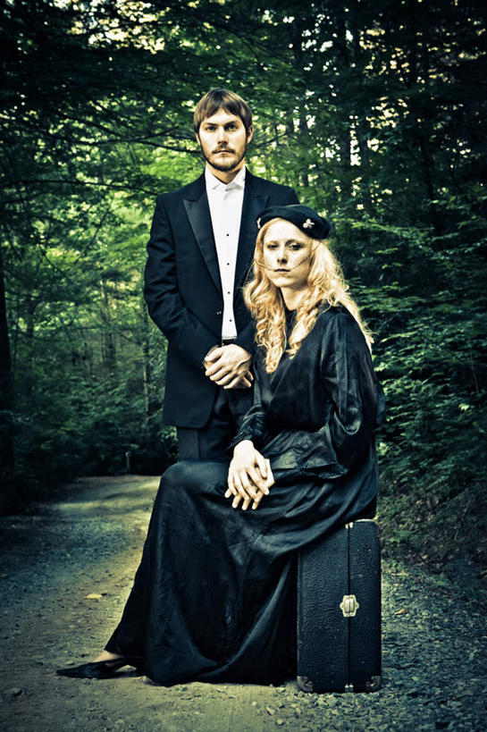 西方人,两个人,站,坐,双手交叉,竖图,室外,白天,正面,婚纱,森林,树林,植物,帽子,皮箱,欧洲,欧洲人,礼帽,树,树木,绿色,黑色,自然,站着,生长,成长,男人,男性,年轻男性,年轻女性,女人,女性,白种人,十字手,站立,坐着,彩图,全身,婚礼服,礼服