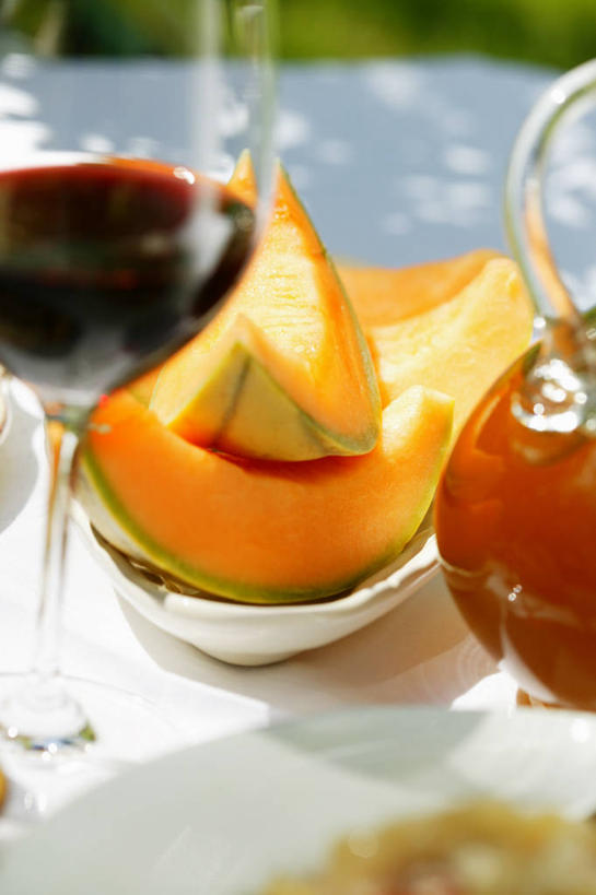 红酒,葡萄酒,无人,竖图,俯视,室内,特写,白天,餐桌,桌子,杯子,水果,切开,阴影,朦胧,模糊,新鲜,反射,高脚杯,罐子,影子,陶瓷,哈密瓜,生食,食品,果实,甜瓜,陶瓷制品,红酒杯,酒类,一杯,玻璃制品,酒,食物,饮料,两个,玻璃瓶,酒杯,瓶子,容器,碗,切,橙色,红葡萄酒,有机食品,绿色食品,餐台,储藏,葡萄酒杯,储存,网纹瓜,甘瓜,剖面,切面,玻璃杯,彩图,高角度拍摄,贮存