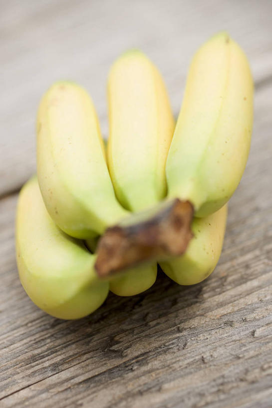 无人,竖图,俯视,室内,特写,白天,桌面,桌子,香蕉,水果,一排,阴影,朦胧,模糊,新鲜,整齐,并列,并排,反射,木制,影子,生食,食品,果实,食物,排列,黄色,木制品,有机食品,绿色食品,队列,平行,甘蕉,彩图,高角度拍摄