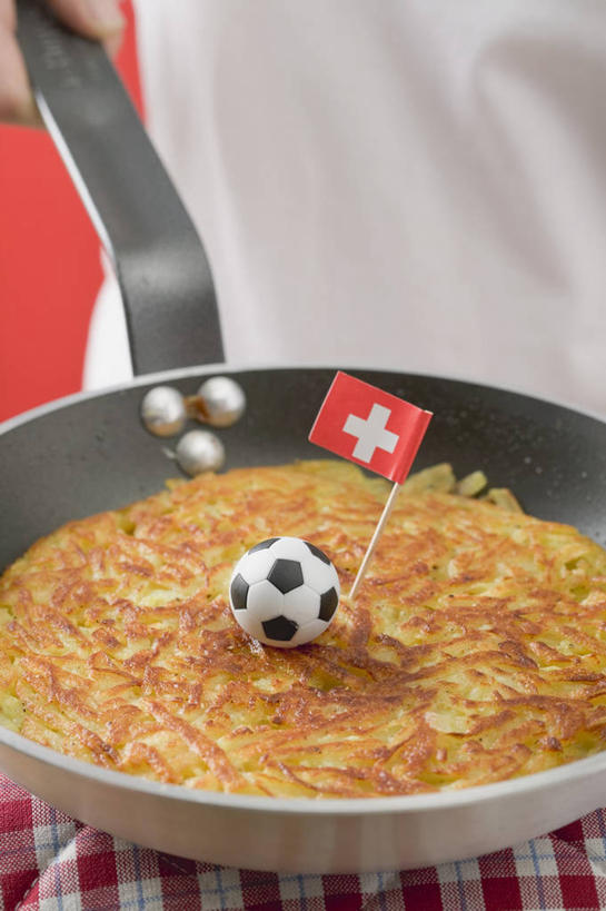 点心,西方人,手,一个人,竖图,俯视,室内,特写,白天,烹饪,足球,厨具,旗帜,国旗,金属制品,欧洲,欧洲人,仅一个年轻女性,仅一个女性,仅一个人,握,阴影,服装,反射,金属,锅子,影子,食品,足球装备,休闲装,文化,运动器械,锅,饼,小吃,食物,糕点,一个,衣服,休闲,手部,休闲服,健身器械,握着,服饰,单个,煎锅,锅具,单手,健身器材,土豆饼,烹饪用具,瑞士国旗,蹴鞠,足球运动,年轻女性,女人,女性,白种人,烹调用具,旗,烹调,半身,彩图,高角度拍摄,运动器材