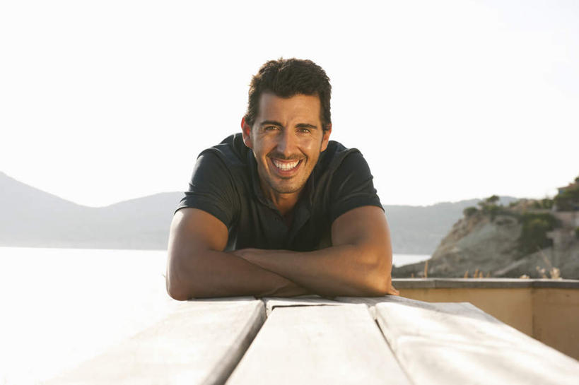 西方人,一个人,栏杆,躺,笑,微笑,露齿笑,横图,室外,白天,正面,草地,草坪,海浪,海洋,山,山脉,植物,欧洲,欧洲人,仅一个男性,仅一个人,仅一个中年男性,阴影,服装,光线,影子,浪花,山峰,围栏,山峦,注视,休闲装,护栏,草,衣服,蓝色,绿色,蓝天,天空,阳光,海水,群山,天,观察,看,趴着,休闲,休闲服,服饰,晴朗,观看,察看,关注,海景,万里无云,卧着,男人,男性,中年男性,白种人,大海,风浪,海,海水的波动,近岸浪,涌浪,晴空,晴空万里,趴,躺着,卧,彩图,全身