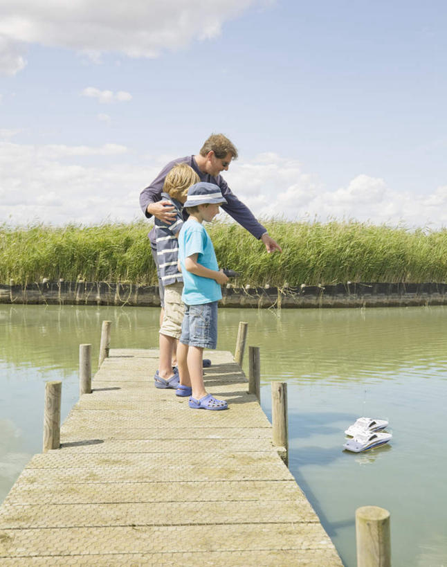 西方人,儿童,中年人,三个人,家庭,父亲,儿子,站,竖图,室外,白天,侧面,游戏,纯洁,草地,草坪,湖,湖泊,水,植物,轮船,船,帽子,欧洲,欧洲人,握,阴影,条纹,服装,光线,木板,影子,湖面,水流,水面,云,云朵,桥,木桥,拿,玩,云彩,拿着,注视,休闲装,娱乐,栈桥,草,小孩,衣服,蓝色,绿色,白云,倒影,蓝天,天空,阳光,模型,遮阳帽,遥控器,交通工具,湖水,天,观察,看,站着,休闲,温暖,温馨,父子,一家人,休闲服,父爱,可爱,童年,童趣,握着,服饰,晴朗,观看,活动,人行桥,木板桥,和睦,察看,倒映,遥控,发泄,关注,消遣,智力,载具,童真,烂漫,无邪,宣泄,反照,天真,男孩,男人,男性,中年男性,白种人,孩子,晴空,玩耍,嬉戏,站立,彩图,全身,融洽,男生