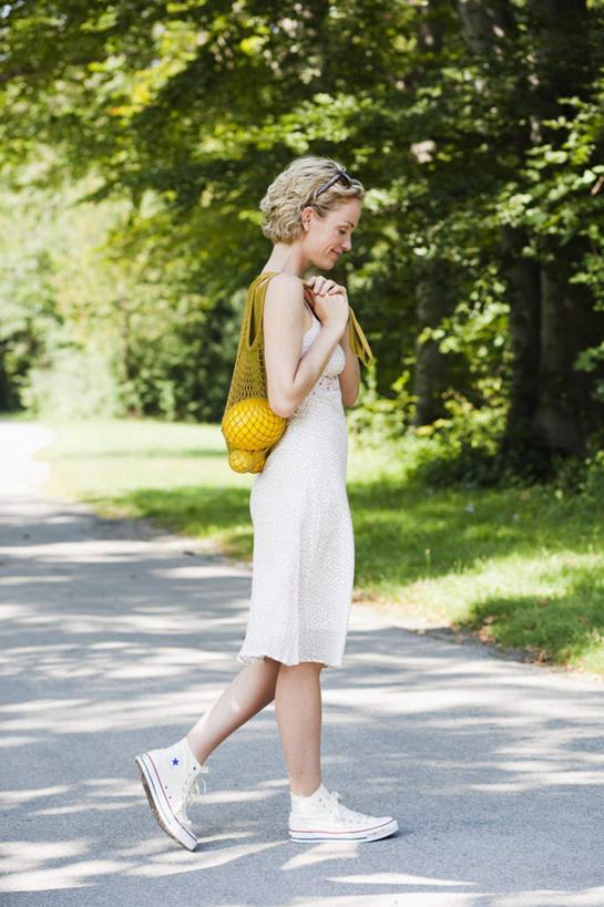 西方人,一个人,走,笑,微笑,露齿笑,竖图,室外,白天,侧面,裙子,草地,草坪,植物,道路,路,欧洲,欧洲人,仅一个女性,仅一个人,握,阴影,连衣裙,光线,包,皮包,影子,小路,交通,注视,草,树,树木,黄色,绿色,白色,阳光,自然,观察,看,仅一个中年女性,金色,握着,生长,成长,观看,吊带裙,察看,关注,女人,女性,中年女性,白种人,卷发,步行,散步,走路,彩图,全身,双肩包,短发