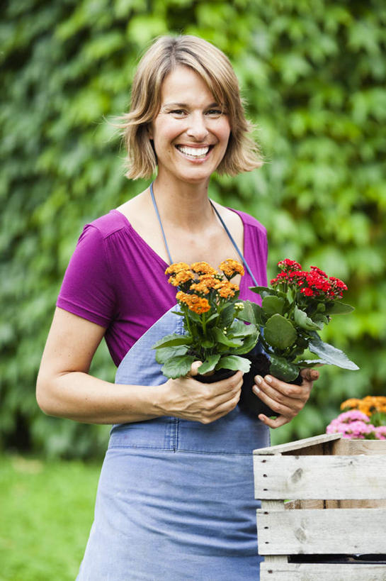 西方人,一个人,站,笑,微笑,露齿笑,竖图,室外,白天,正面,植物,椅子,花盆,欧洲,欧洲人,仅一个女性,仅一个人,握,阴影,服装,盛开,光线,围裙,影子,长椅,木椅,园艺,棕色,拿,花蕾,拿着,注视,休闲装,花,花瓣,花朵,鲜花,树,树木,衣服,蓝色,绿色,紫色,阳光,自然,花苞,花蕊,观察,看,站着,仅一个中年女性,休闲,休闲服,握着,服饰,生长,成长,观看,察看,关注,女人,女性,中年女性,白种人,卷发,站立,半身,彩图,短发