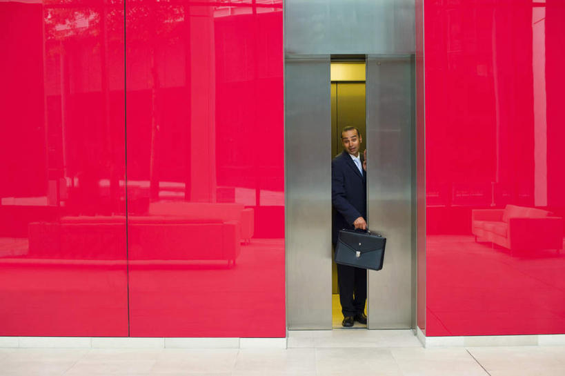 西方人,一个人,商务人士,商务男性,站,横图,室内,白天,正面,衬衫,电梯,欧洲,欧洲人,仅一个男性,仅一个人,仅一个中年男性,握,套装,包,公文包,墙,运输工具,拿,拎,拿着,注视,墙壁,墙面,红色,观察,看,站着,握着,升降梯,公事包,观看,察看,关注,商务装,工薪阶层,男人,男性,中年男性,白种人,白领,上班族,站立,彩图,全身,衬衣,升降设备,拎着