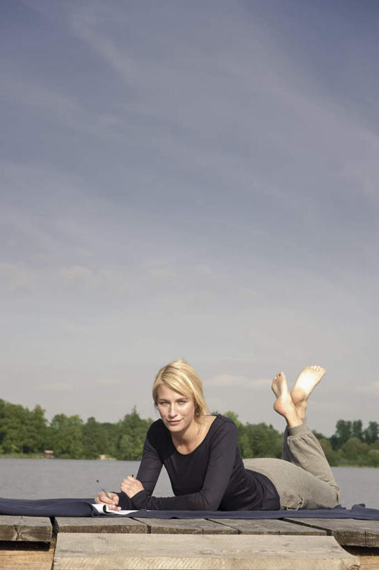 西方人,一个人,码头,笑,微笑,竖图,室外,白天,正面,湖,湖泊,树林,水,植物,港口,欧洲,欧洲人,仅一个年轻女性,仅一个女性,仅一个人,握,写字,阴影,服装,光线,笔,木板,毯子,影子,湖面,水流,水面,云,云朵,桥,棕色,办公用品,记事本,木桥,拿,云彩,拿着,注视,休闲装,光脚,水笔,栈桥,文具,树,树木,衣服,蓝色,绿色,白云,蓝天,天空,阳光,自然,本子,笔记本,学习用品,垫子,湖水,天,观察,看,趴着,休闲,赤脚,休闲服,金色,握着,服饰,生长,晴朗,成长,观看,人行桥,木板桥,文具用品,察看,书写,关注,游艇码头,沙滩垫,年轻女性,女人,女性,白种人,长发,晴空,趴,彩图,全身,摆渡口,埠头,渡口,渡头,港湾,海港,口岸