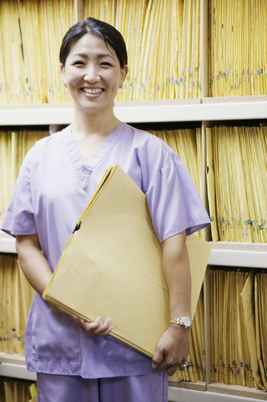 西方人,一个人,站,笑,微笑,露齿笑,竖图,室内,白天,正面,欧洲,欧洲人,仅一个女性,仅一个人,握,档案,纸袋,拿,拿着,注视,架子,排列,观察,看,站着,仅一个中年女性,握着,观看,察看,关注,女人,女性,中年女性,白种人,半身,彩图