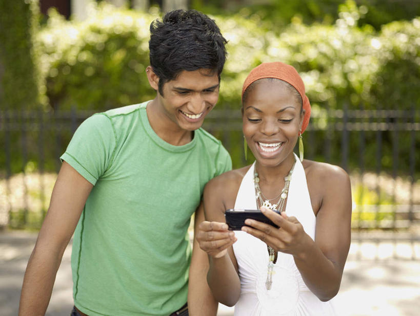 西方人,两个人,站,笑,打电话,微笑,露齿笑,横图,室外,白天,正面,植物,电话,手机,欧洲,非洲,黑人,欧洲人,阴影,服装,朦胧,模糊,光线,头巾,影子,注视,休闲装,通讯设备,树,树木,衣服,绿色,阳光,自然,低头,观察,看,站着,休闲,休闲服,服饰,生长,成长,观看,察看,关注,一部,交流,男人,男性,年轻男性,女人,女性,中年女性,非洲人,沟通,通话,站立,半身,彩图