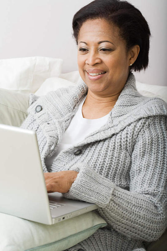 西方人,一个人,客厅,坐,笑,微笑,露齿笑,竖图,室内,白天,正面,电脑,笔记本电脑,靠垫,沙发,欧洲,非洲,黑人,欧洲人,仅一个女性,仅一个人,敲打,服装,网络,靠枕,注视,休闲装,输入,通讯设备,衣服,抱枕,枕头,打字,观察,看,仅一个中年女性,休闲,休闲服,服饰,观看,点击,敲击,察看,无线,起居室,关注,通信设备,无线网络,布艺沙发,无线上网,便携式电脑,客堂,按键,手提电脑,女人,女性,中年女性,非洲人,坐着,半身,彩图