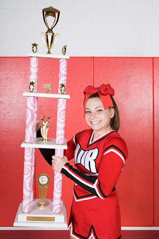 西方人,一个人,站,笑,微笑,露齿笑,竖图,室内,白天,正面,裙子,成功,胜利,欧洲,欧洲人,仅一个年轻女性,仅一个女性,仅一个人,握,连衣裙,装饰,墙,拿,拿着,注视,墙壁,墙面,红色,白色,发箍,发饰,蝴蝶结,饰品,观察,看,站着,光彩,握着,头箍,观看,察看,关注,荣誉,发卡,奖品,配饰,荣耀,光荣,年轻女性,女人,女性,白种人,站立,半身,彩图,奖杯