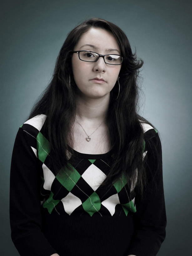 西方人,一个人,站,竖图,室内,白天,正面,项链,欧洲,欧洲人,仅一个年轻女性,仅一个女性,仅一个人,阴影,灰色背景,服装,生气,反射,眼镜,影子,注视,休闲装,装饰品,衣服,饰品,首饰,观察,看,站着,休闲,休闲服,愤怒,摄影,服饰,影棚,观看,恼怒,察看,愤慨,怒气,气愤,发怒,关注,怒火,情绪,脾气,近视眼镜,忿怒,怨恨,强烈,气忿,愤恨,肝火,激动,年轻女性,女人,女性,白种人,站立,半身,彩图,影棚拍摄,拍摄