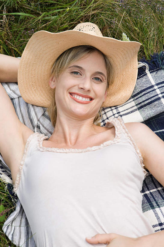 西方人,一个人,躺,笑,微笑,露齿笑,竖图,俯视,室外,白天,草地,草坪,植物,帽子,欧洲,欧洲人,仅一个女性,仅一个人,服装,草帽,坐垫,注视,休闲装,草,衣服,绿色,观察,看,仅一个中年女性,休闲,休闲服,服饰,观看,察看,关注,野餐垫,野餐地毯,多功能毯,卧着,女人,女性,中年女性,白种人,躺着,卧,半身,彩图,高角度拍摄