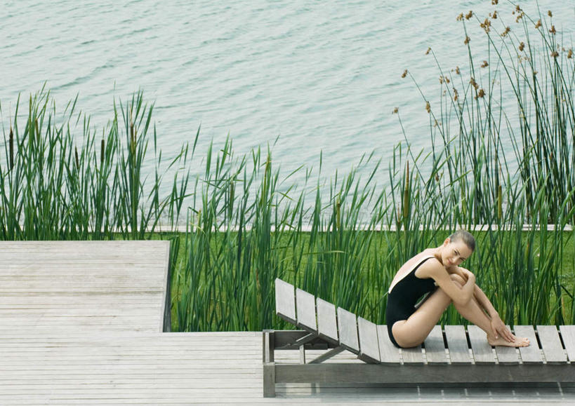 西方人,一个人,坐,笑,微笑,横图,俯视,室外,白天,泳装,比基尼,旅游,度假,草地,草坪,湖,湖泊,水,植物,地板,椅子,欧洲,欧洲人,仅一个年轻女性,仅一个女性,仅一个人,木椅,湖面,水流,水面,地面,注视,娱乐,木地板,草,绿色,湖水,观察,看,享受,休闲,放松,观看,察看,关注,年轻女性,女人,女性,白种人,坐着,彩图,高角度拍摄,全身,三点式,泳衣