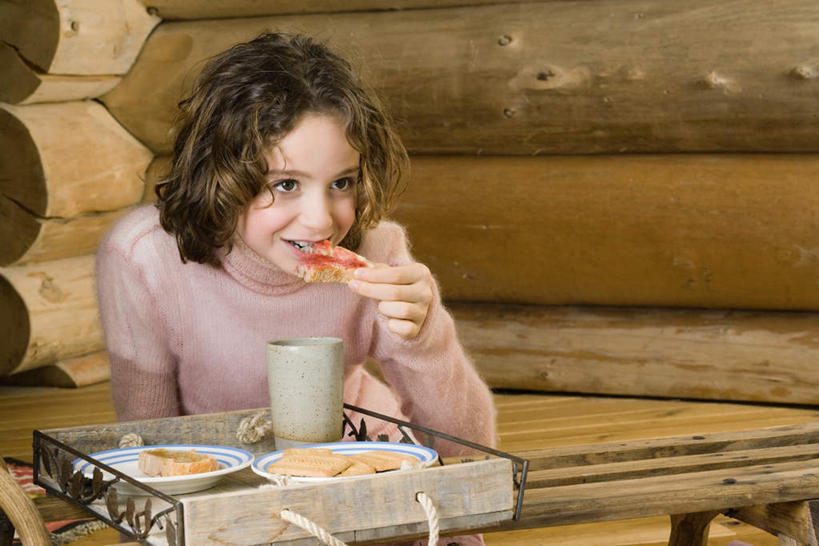 点心,面包,西方人,儿童,一个人,家,木屋,坐,笑,吃,微笑,露齿笑,横图,室内,白天,正面,毛衣,餐桌,桌子,杯子,欧洲,欧洲人,仅一个女性,仅一个人,握,木制,木头,墙,调料,酱料,酱汁,佐料,食品,面点,调味品,拿,调味料,拿着,注视,酱,墙壁,墙面,住宅,食物,糕点,小孩,水杯,观察,看,仅一个小孩,握着,餐台,观看,察看,关注,女孩,女人,女性,白种人,孩子,茶杯,嚼,食,坐着,半身,彩图,绒衣,套衫,套头毛衣,线衣,茅舍,茅屋,棚屋,小木屋,小屋,女生