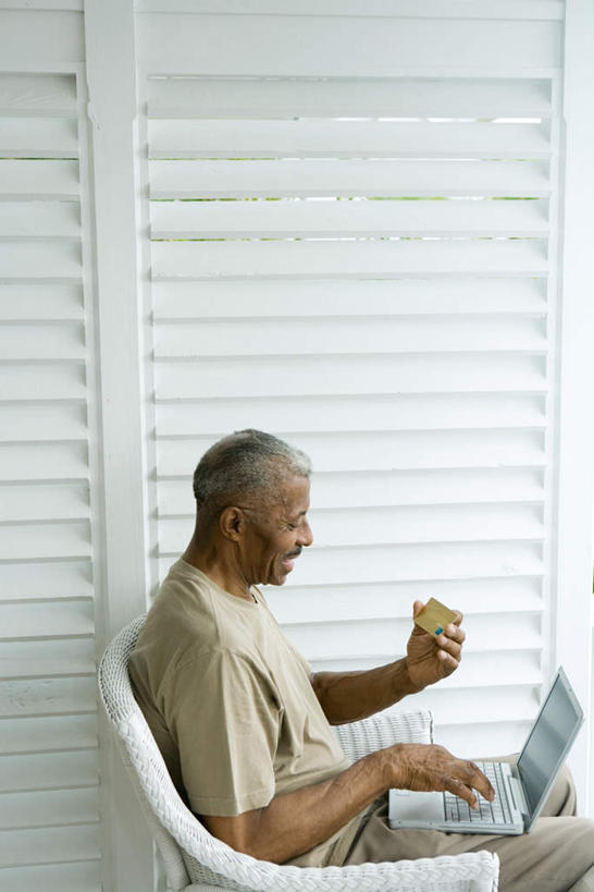 西方人,一个人,坐,笑,微笑,竖图,室内,白天,侧面,信用卡,电脑,笔记本电脑,椅子,欧洲,非洲,黑人,欧洲人,仅一个男性,仅一个人,一张,敲打,握,网络,墙,拿,拿着,注视,输入,通讯设备,墙壁,墙面,打字,低头,看,仅一个老年男性,卡,握着,储蓄卡,点击,一台,敲击,无线,通信设备,无线网络,无线上网,便携式电脑,银行卡,按键,手提电脑,老年男性,男人,男性,非洲人,坐着,半身,彩图