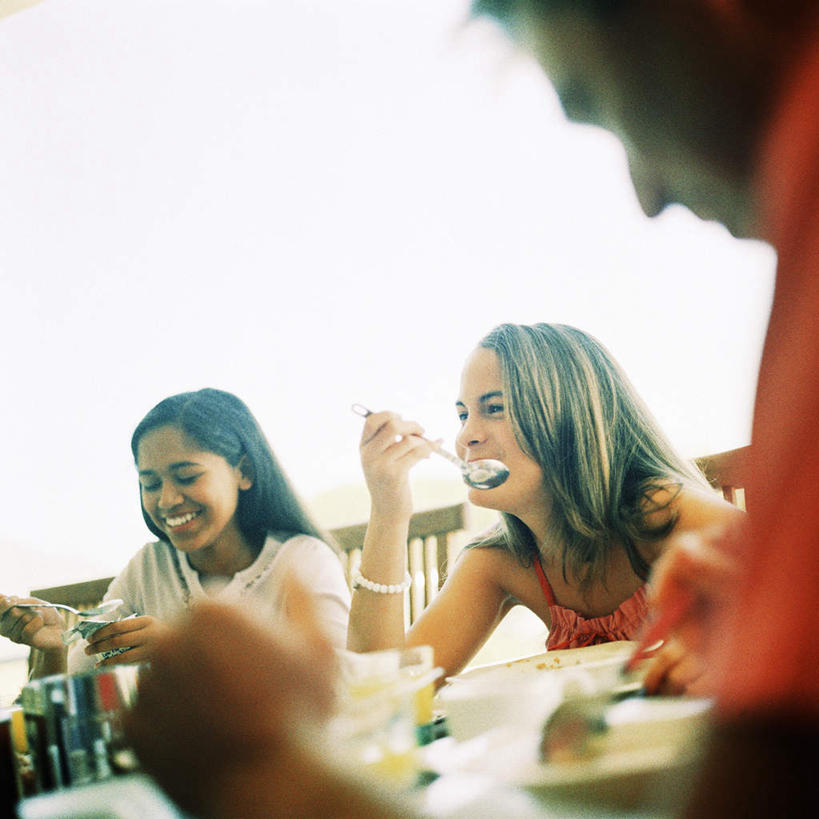 西方人,三个人,伙伴,朋友,坐,笑,微笑,露齿笑,方图,室外,白天,正面,友谊,餐桌,桌子,餐具,欧洲,欧洲人,碟子,盘,勺子,拿,拿着,盘子,调羹,碟,汤匙,餐台,友情,男人,男性,年轻男性,年轻女性,女人,女性,白种人,坐着,半身,彩图