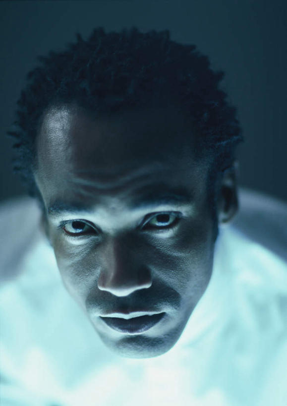 西方人,脸,头,脸颊,头发,一个人,笑,微笑,竖图,俯视,室内,特写,白天,欧洲,非洲,黑人,欧洲人,仅一个男性,仅一个人,蓝色背景,服装,注视,休闲装,仅一个年轻男性,衣服,白色,黑色,观察,看,休闲,休闲服,摄影,服饰,影棚,观看,察看,关注,男人,男性,年轻男性,非洲人,头部,卷发,脸部,脸蛋,面部,抬头,仰头,半身,彩图,高角度拍摄,影棚拍摄,拍摄