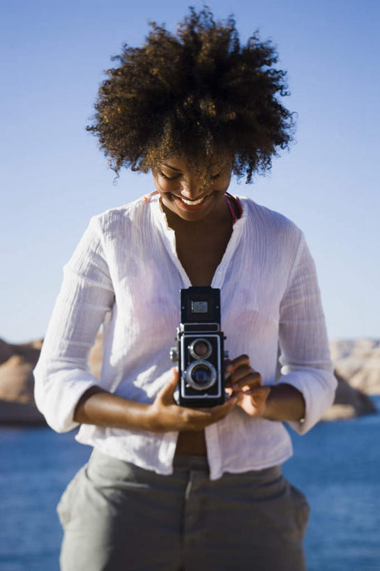 西方人,一个人,站,笑,微笑,露齿笑,竖图,室外,白天,正面,河流,石头,山,山脉,水,相机,欧洲,非洲,黑人,欧洲人,仅一个年轻女性,仅一个女性,仅一个人,握,阴影,服装,光线,石子,影子,河水,山顶,山峰,水流,山峦,拿,拿着,注视,休闲装,拍照,衣服,蓝色,白色,蓝天,天空,阳光,数码相机,群山,天,低头,观察,看,站着,休闲,休闲服,握着,摄影,服饰,晴朗,观看,察看,关注,沉积岩,万里无云,垂头,颠峰,极峰,水成岩,年轻女性,女人,女性,非洲人,照相机,石块,岩石,晴空,晴空万里,站立,半身,彩图,照相