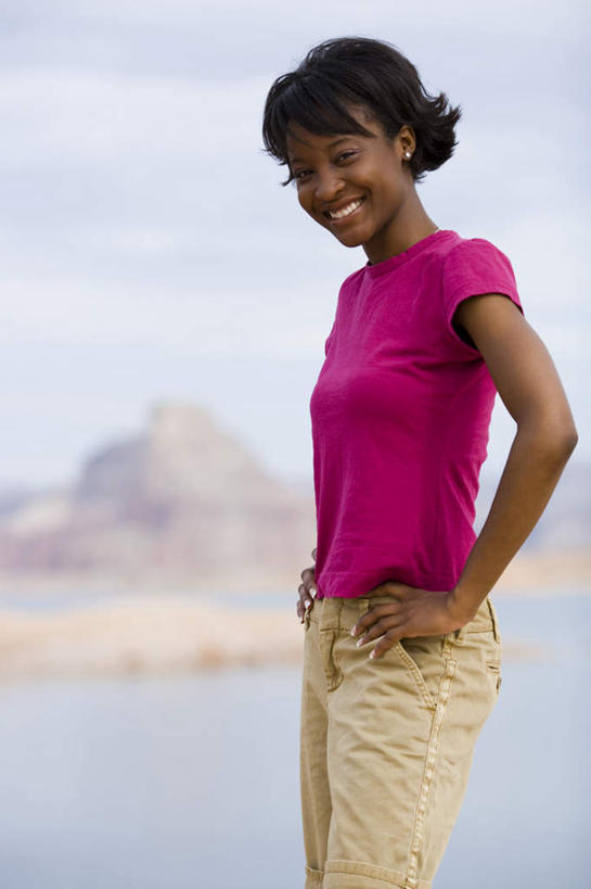 西方人,一个人,站,笑,微笑,露齿笑,竖图,室外,白天,侧面,海浪,海洋,石头,山,山脉,欧洲,非洲,黑人,欧洲人,仅一个年轻女性,仅一个女性,仅一个人,阴影,服装,朦胧,模糊,光线,石子,影子,浪花,山顶,山峰,云,云朵,山峦,云彩,注视,休闲装,手叉腰,衣服,粉色,蓝色,白云,蓝天,天空,阳光,海水,群山,天,叉腰,观察,看,站着,休闲,休闲服,服饰,晴朗,观看,察看,双手叉腰,关注,海景,沉积岩,颠峰,极峰,水成岩,年轻女性,女人,女性,非洲人,大海,风浪,海,海水的波动,近岸浪,石块,岩石,涌浪,晴空,站立,半身,彩图