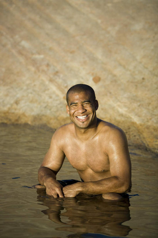 西方人,一个人,蹲,笑,微笑,露齿笑,竖图,室外,白天,正面,湖,湖泊,石头,水,欧洲,非洲,黑人,欧洲人,仅一个男性,仅一个人,阴影,光线,石子,影子,湖面,水流,水面,注视,裸露,仅一个年轻男性,阳光,湖水,观察,看,观看,察看,关注,裸,沉积岩,水成岩,男人,男性,年轻男性,非洲人,石块,岩石,蹲着,半身,彩图