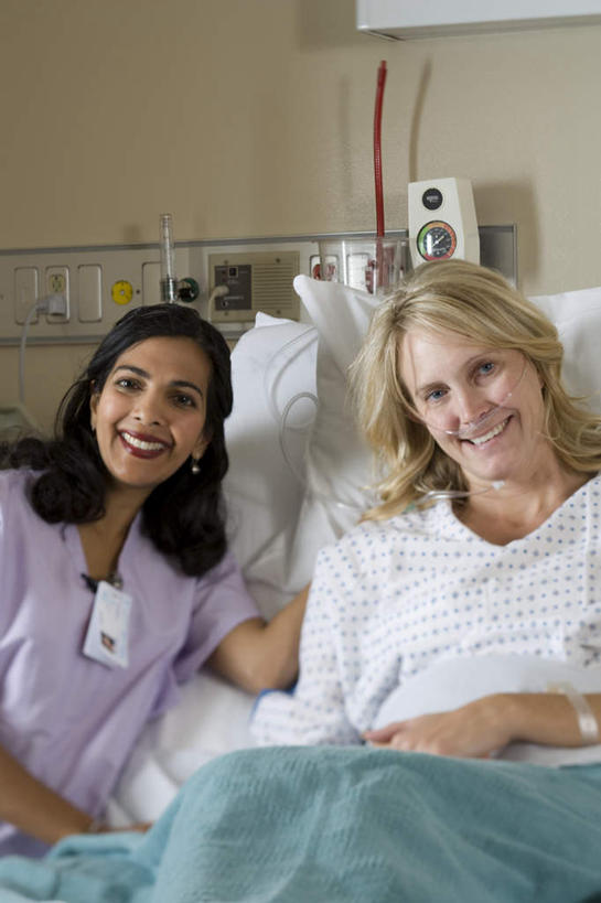 西方人,两个人,医生,病人,医院,坐,笑,微笑,露齿笑,竖图,室内,白天,正面,工作服,制服,床,靠垫,欧洲,欧洲人,亚洲,阴影,反射,影子,墙,床单,靠枕,注视,被子,标识,吊牌,墙壁,墙面,胸牌,垫子,枕头,观察,看,医护人员,医疗人员,搭,单人床,观看,察看,徽章,被单,搭着,关注,病患,身份,胸章,医疗机构,胸卡,病号服,编号牌,雕刻牌,工号牌,胸号牌,胸徽,员工牌,工作制服,女人,女性,中年女性,白种人,亚洲人,印度人,大夫,患者,就医者,坐着,半身,彩图,工作套服,病院,诊所