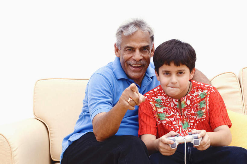 儿童,老年人,两个人,家庭,祖父,客厅,坐,笑,微笑,露齿笑,横图,室内,白天,正面,游戏,纯洁,沙发,亚洲,指,服装,墙,拿,玩,拿着,注视,休闲装,方向,娱乐,墙壁,墙面,小孩,衣服,红色,蓝色,白色,观察,看,手势,休闲,温暖,温馨,一家人,休闲服,可爱,童年,童趣,服饰,游戏机,爷爷,观看,祖孙,和睦,察看,起居室,指向,关注,布艺沙发,童真,烂漫,无邪,外公,外祖父,外孙,外孙子,客堂,天真,老年男性,男孩,男人,男性,亚洲人,印度人,孩子,孙子,玩耍,嬉戏,坐着,半身,彩图,融洽,男生