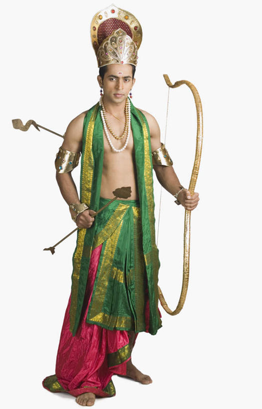 一个人,站,竖图,室内,白天,白色背景,正面,民族服装,帽子,项链,亚洲,仅一个男性,仅一个人,握,服装,弓,弓箭,拿,拿着,注视,装饰品,仅一个年轻男性,衣服,耳环,饰品,首饰,观察,看,站着,握着,摄影,服饰,影棚,观看,合金,黄铜,豆蔻,察看,衣着,穿着,关注,表演服,演出服,印度教,耳饰,衣饰,道具服,男人,男性,年轻男性,亚洲人,印度人,站立,半身,彩图,影棚拍摄,传统服装,民俗服,拍摄,传统文化