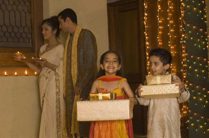 儿童,四个人,家庭,夫妻,母亲,父亲,女儿,儿子,站,捧,笑,微笑,露齿笑,横图,室内,白天,正面,民族服装,爱情,纯洁,卧室,蜡烛,礼盒,礼物,托盘,亚洲,握,阴影,朦胧,模糊,光线,火焰,影子,纸盒,烛光,墙,灯光,浪漫,燃烧,拿,拿着,注视,墙壁,墙面,灯,盒子,小孩,包装盒,盘子,礼品盒,灯具,点燃,观察,看,站着,温暖,温馨,父女,父子,母女,母子,一家人,恩爱,父爱,可爱,母爱,童年,童趣,握着,恋人,服饰,礼品,观看,飘逸,和睦,察看,庄重,照明设备,关注,追求,童真,烂漫,无邪,纱丽,雅致,纱丽服,清婉,妍丽,天真,男孩,男人,男性,年轻男性,年轻女性,女孩,女人,女性,亚洲人,印度人,孩子,年轻人,夫妇,情侣,装饰画,端,端着,捧着,手捧,站立,半身,彩图,传统服装,民俗服,睡房,卧房,伴侣,融洽,男生,女生,奢华