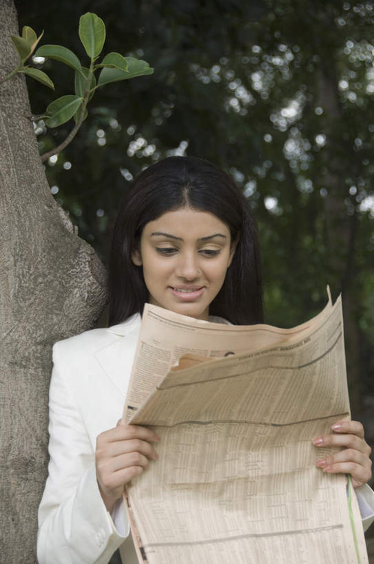 一个人,商务人士,商务女性,站,笑,微笑,露齿笑,竖图,室外,白天,正面,西装,阅读,植物,报纸,亚洲,仅一个年轻女性,仅一个女性,仅一个人,握,学习,套装,正装,朦胧,模糊,拿,拿着,注视,职业装,树,树木,绿色,自然,观察,看,站着,浏览,握着,生长,成长,观看,察看,关注,商务装,工薪阶层,年轻女性,女人,女性,亚洲人,印度人,白领,上班族,站立,半身,彩图