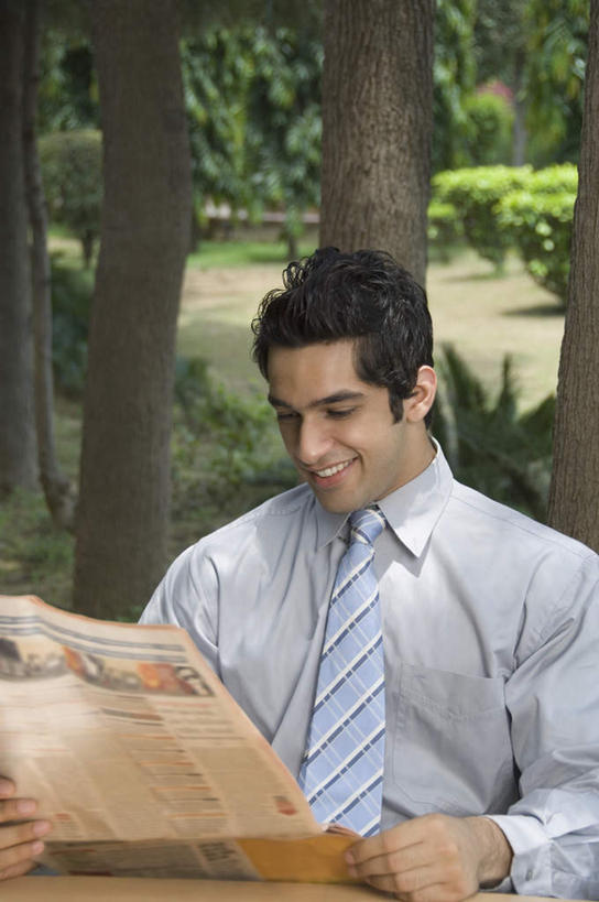 一个人,商务人士,商务男性,坐,笑,微笑,露齿笑,竖图,室外,白天,正面,衬衫,阅读,植物,桌面,桌子,报纸,亚洲,仅一个男性,仅一个人,握,学习,套装,木制,领带,拿,拿着,注视,树,树木,仅一个年轻男性,绿色,自然,木制品,观察,看,浏览,握着,生长,成长,观看,察看,象征,庄重,关注,商务装,身份,工薪阶层,正式,地位,男人,男性,年轻男性,亚洲人,印度人,白领,上班族,坐着,半身,彩图,衬衣