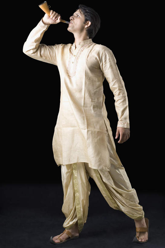 一个人,站,竖图,室内,白天,侧面,民族服装,印度,亚洲,仅一个男性,仅一个人,握,黑色背景,服装,拿,拿着,注视,喇叭,仅一个年轻男性,衣服,话筒,观察,看,站着,握着,摄影,服饰,影棚,观看,察看,衣着,穿着,关注,传声筒,衣饰,男人,男性,年轻男性,亚洲人,印度人,站立,彩图,全身,影棚拍摄,传统服装,民俗服,拍摄,传统文化