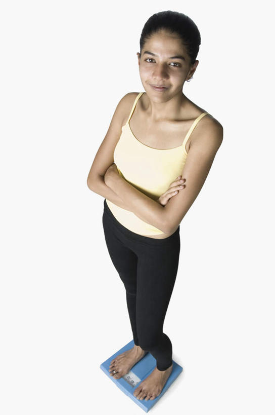 一个人,站,笑,双手交叉,微笑,露齿笑,竖图,俯视,室内,白天,运动服,仪器,亚洲,仅一个年轻女性,仅一个女性,仅一个人,服装,生活,注视,衣服,观察,看,站着,健康,服饰,观看,察看,衡量,双手抱胸,体重,衣着,穿着,关注,计量,衡器,健康秤,衣饰,年轻女性,女人,女性,亚洲人,印度人,秤,体重秤,站立,彩图,高角度拍摄,全身,运动装