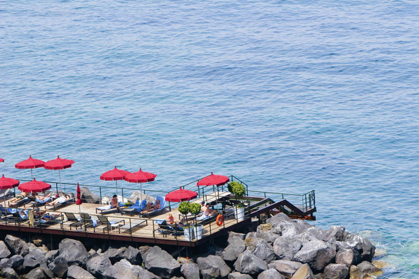 西方人,码头,站,坐,横图,俯视,室外,白天,旅游,度假,海浪,海洋,石头,美景,港口,椅子,意大利,欧洲,欧洲人,行人,游客,游人,服装,伞,石子,雨伞,遮阳伞,躺椅,景观,浪花,许多人,注视,休闲装,娱乐,阳伞,路人,旅客,衣服,自然,海水,观察,看,站着,一群人,享受,休闲,休闲服,景色,放松,服饰,观看,沙滩椅,察看,太阳伞,关注,南欧,自然风光,海景,意大利共和国,坎帕尼亚,索伦托半岛,索伦托,坎帕尼亚大区,过客,男人,男性,年轻男性,年轻女性,女人,女性,白种人,大海,风浪,海,海水的波动,近岸浪,石块,岩石,涌浪,站立,坐着,彩图,高角度拍摄,全身,摆渡口,埠头,渡口,渡头,港湾,海港,货运码头,口岸,商港