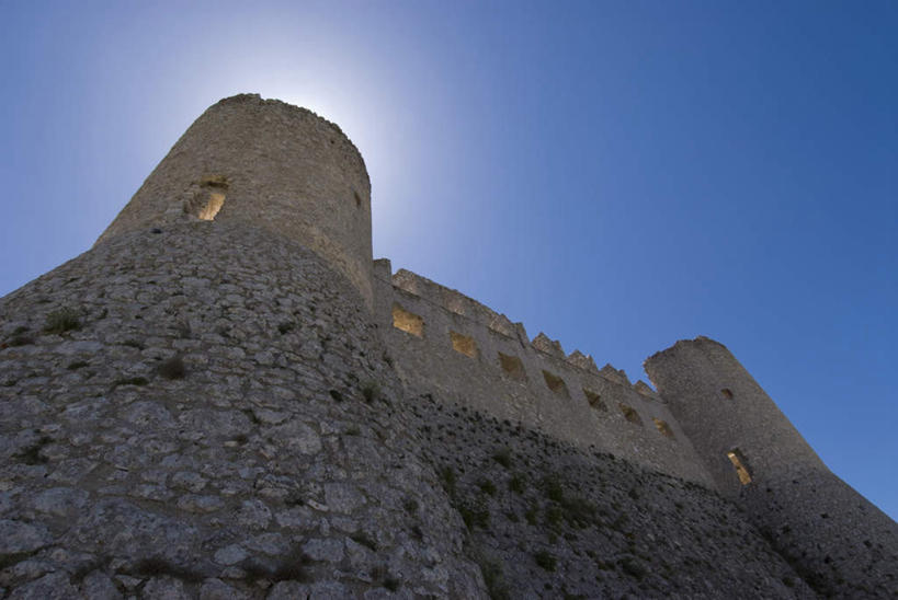 无人,横图,室外,白天,仰视,旅游,度假,石头,名胜古迹,标志建筑,地标,建筑,意大利,欧洲,阴影,遗迹,光线,石子,影子,堡垒,城堡,墙,古迹,文物,娱乐,建设,古建筑,废墟,墙壁,墙面,蓝色,蓝天,天空,阳光,天,享受,休闲,旅游胜地,放松,晴朗,要塞,南欧,古文明,万里无云,意大利共和国,设防,阿布鲁佐,阿布鲁佐大区,石块,岩石,晴空,晴空万里,彩图,低角度拍摄