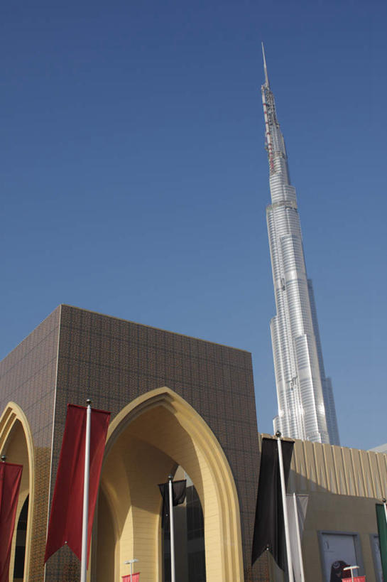 无人,高楼大厦,竖图,室外,白天,仰视,度假,美景,城市风光,标志建筑,城市,大厦,地标,建筑,摩天大楼,旗帜,阿联酋,亚洲,阴影,繁华,光线,影子,景观,娱乐,旗子,建设,红色,蓝色,蓝天,天空,阳光,天,享受,休闲,景色,放松,晴朗,西亚,阿拉伯联合酋长国,迪拜,万里无云,迪拜塔,哈利法塔,比斯迪拜塔,旌旗,旗号,繁荣,杜拜,发达,迪拜大厦,晴空,晴空万里,彩图,低角度拍摄,大楼,高层建筑,高楼,摩天楼